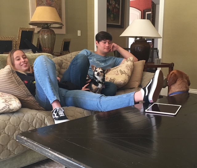 Your Puppy’s First July 4th 2 people sitting on sofa with dog